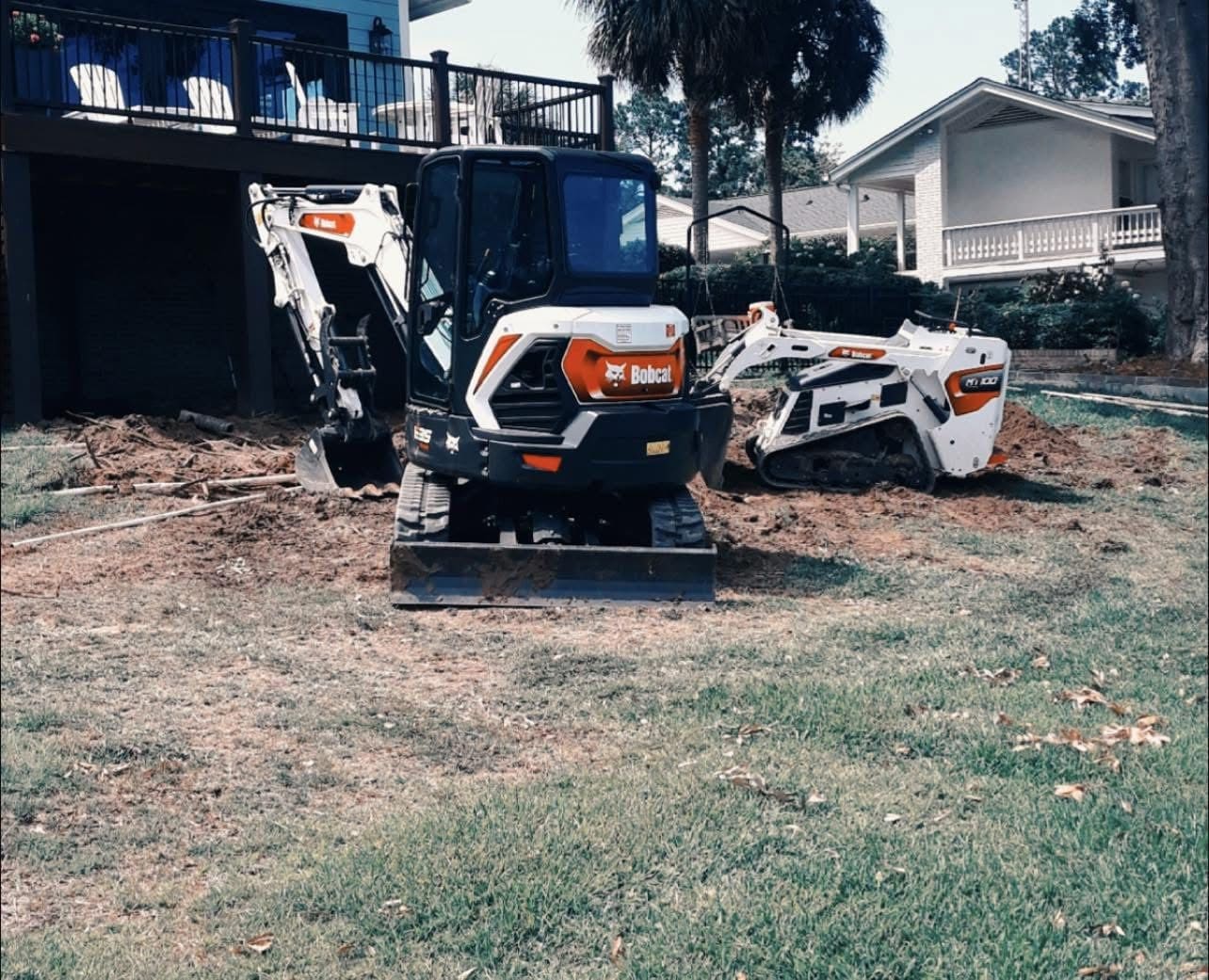 Bobcat excavator and skid steer loader on residential property during construction work